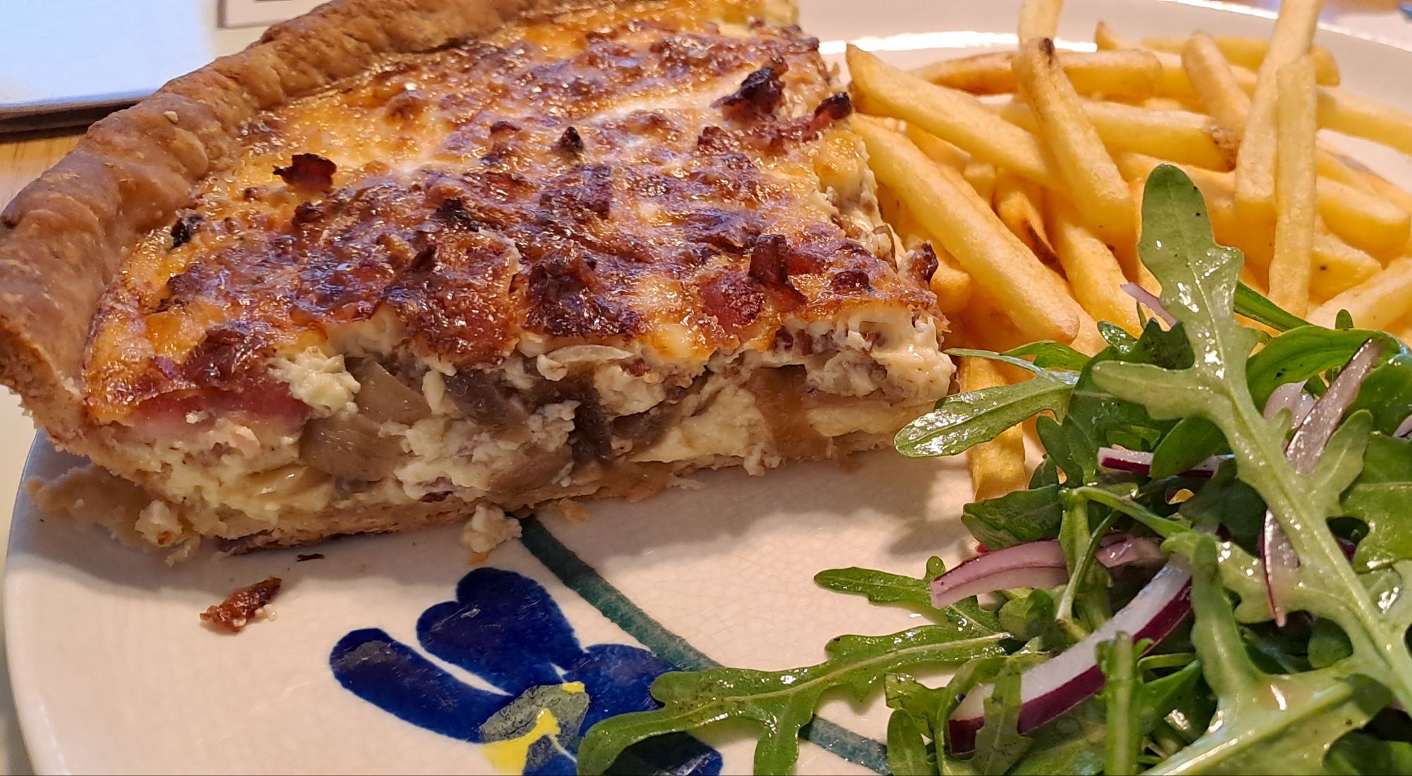 Cheesy quiche Lorraine with salad and chips